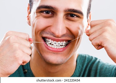 Photo Of Young Man With Braces Using Dental Floss,Dental Hygiene