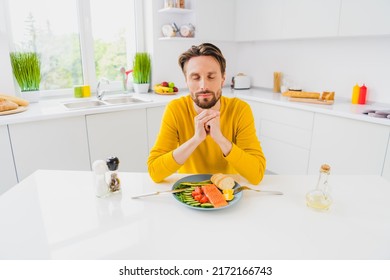 Photo of young man dreamy thoughtful pray grateful eat yummy fish vegetables kitchen supper veggies indoors - Shutterstock ID 2172166743