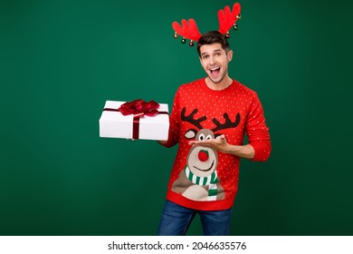 Photo Of Young Man Happy Positive Smile Hold Present Box Party Winter Holiday Christmas Isolated Over Green Color Background