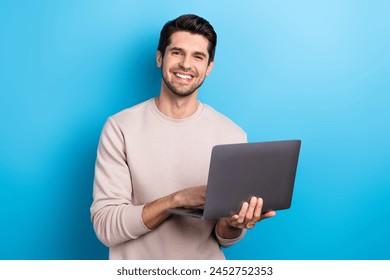 Photo of young nice man use wireless laptop coworking wear beige sweatshirt isolated on blue color background - Powered by Shutterstock