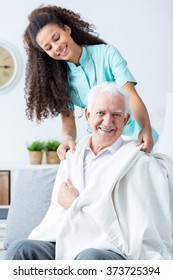Photo of young nurse supporting ill old man