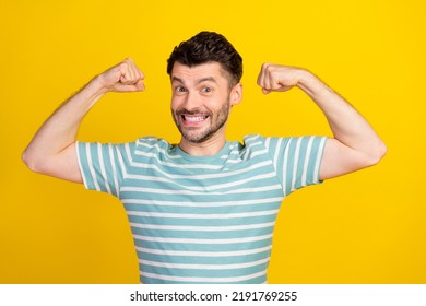 Photo Of Young Positive Man Arm Flex Show Biceps Toothy Smile Look Camera Isolated On Yellow Color Background