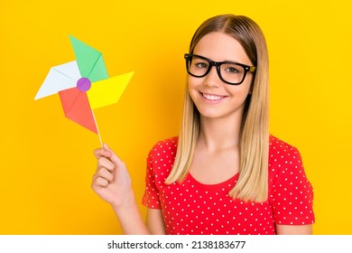 Photo Of Young Pretty Girl Good Mood Hold Paper Spinner Windmill Isolated Over Yellow Color Background