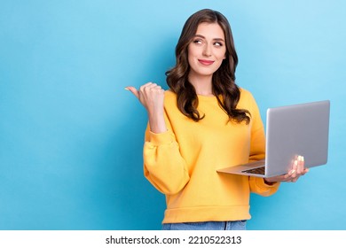 Photo Of Young Pretty Gorgeous Cute Minded Woman Hold Computer Facebook Developer Finger Point Empty Space Interested Look Isolated On Blue Color Background