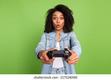 Photo of young pretty lady play game joystick station free time competition isolated over green color background