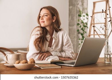 Photo of young pretty redhead business woman sit indoors in office using laptop computer. - Powered by Shutterstock