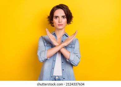 Photo of young pretty serious woman crossed hands show no stop forbidden symbol isolated over yellow color background