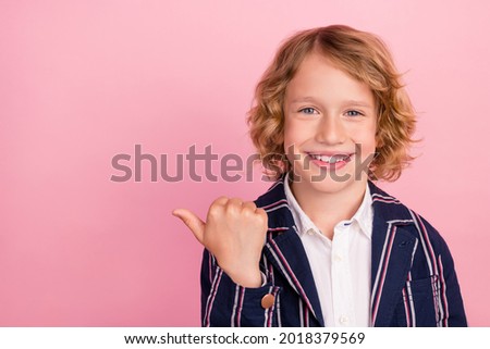 Photo of young school boy happy positive smile indicate thumb empty space recommend advertise isolated over pastel color background