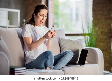 Photo Of Young Shocked Amazed Surprised Businesswoman Sit Sofa Remote Working At Home Hold Smartphone See Bad News