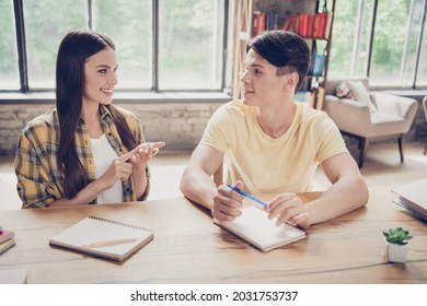 Photo of young smiling two people students talking writing in notebook library girl counting explain math indoors