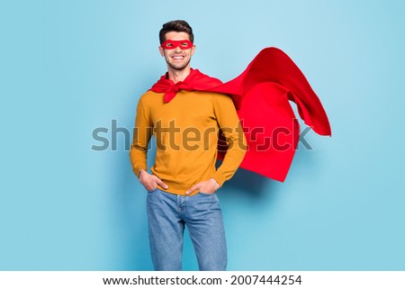 Photo of young superman happy positive smile hands in pocket power strong isolated over blue color background