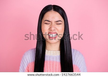 Photo of young unhappy angry mad furious girl having problem grit teeth with close eyes isolated on pink color background