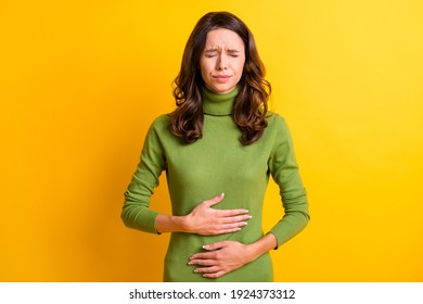 Photo of young unhappy unwell sick ill woman hold hand on stomach suffers pain pms isolated on yellow color background