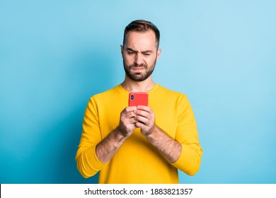 Photo Of Young Unhappy Upset Sad Unsure Uncertain Man See Dislike Bad Comment In Phone Isolated On Yellow Color Background