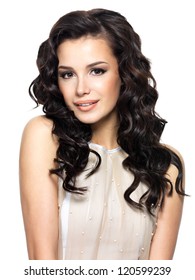 Photo of  young  woman with beauty long curly hair. Fashion model posing at studio.