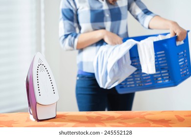 Photo Of Young Woman Bringing The Clean Laundry To Iron