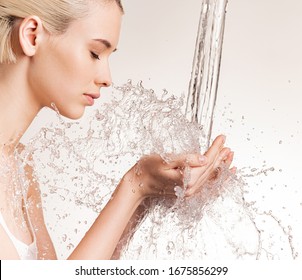 Photo Of  Young Woman With Clean Skin And Splash Of Water. Blonde Woman With Drops Of Water Near Her Face. Spa Treatment. Girl Washing Hands With Water. Water And Body. 