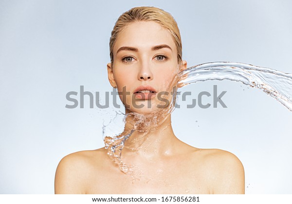 Photo\
of  young woman with clean skin and splash of water. Portrait of\
blonde woman with drops of water around her face. Spa treatment.\
Girl washing her body with water. Water and\
body.