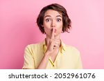 Photo of young woman cover lips finger shh confidential shut up keep secret isolated over pink color background