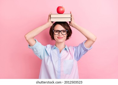 Photo of young woman happy positive smile hold books apple on head balance isolated over pastel color background - Powered by Shutterstock