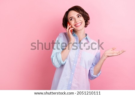 Photo of young woman happy positive smile speak talk call smartphone isolated over pink color background