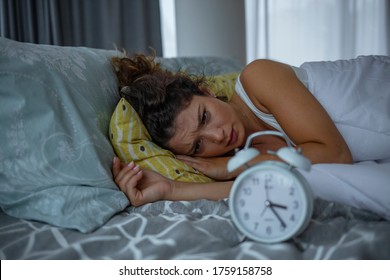 Photo Of A Young Woman Lying In Bed At Night, Wide Awake With A Case Of Insomnia. Depressed Woman Awake In The Night, She Is Touching Her Forehead And Suffering From Insomnia