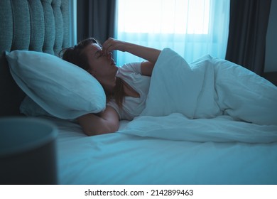 Photo Of A Young Woman Lying In Bed At Night, Wide Awake With A Case Of Insomnia. Sleep Disorder, Insomnia. Young Blonde Woman Lying On The Bed Awake 