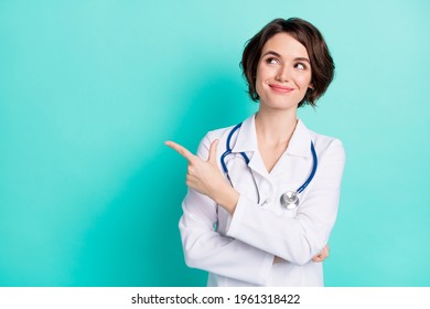 Photo of young woman nurse happy smile look indicate finger empty space ad promo advise choice isolated over teal color background - Powered by Shutterstock