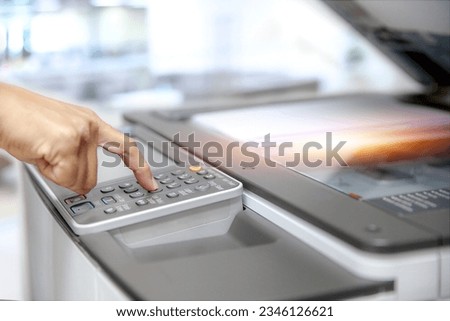 Photocopier printer, Close up hand office man press copy button on panel to using the copier or photocopy machine for scanning document or printing paper or Xerox a sheet.