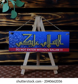 PHOTOGRAPH OF ASSALAMUALAIKUM FRAME WRITTEN WITH CALLIGRAPHY WITH WOOD BACKGROUND