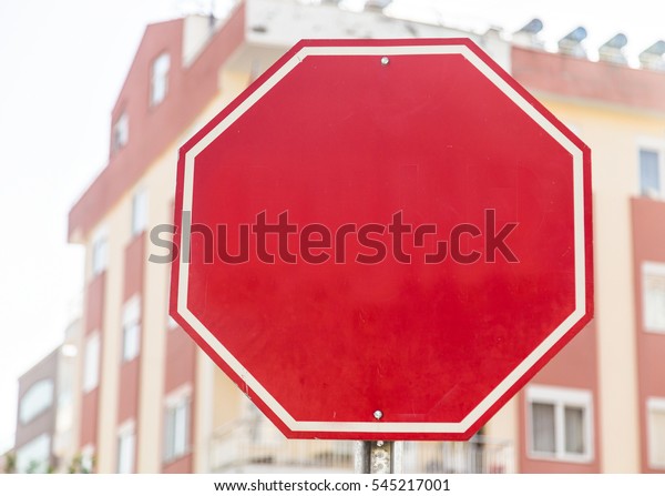 Photograph of a blank red traffic stop sign with\
all text letters\
removed