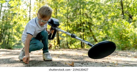 Photograph Of Boy Using A Metal Detector To Search For Lost Treasure On A Sea Sandy Beach