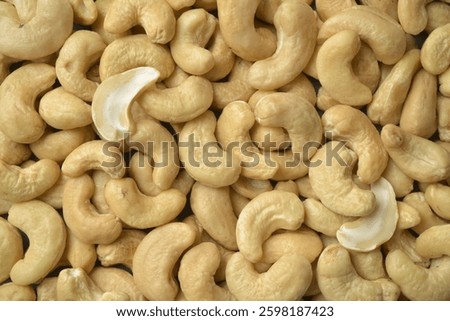 Photograph of cashews nuts in diffused even light. Top view. Healthy eating and snacking. Source of protein and magnesium, whole foods. Cashew background. 