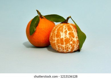 Photograph Of A Couple Of Tangerinewith With Leaf Isolated In Studio With Light Bluebackground