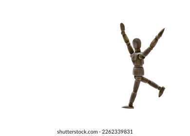 Photograph of a dark colored wooden mannequin with white background, it is in motion, with arms open and stretched upwards. Photo to be able to cut out. Concepts. Selective focus. Space for copy