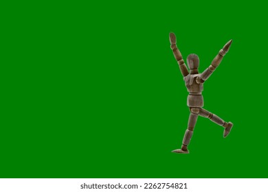 Photograph of a dark colored wooden mannequin with green background, it is in motion, with arms open and stretched upwards. Photo to be able to cut out. Concepts. Selective focus. Space for copy