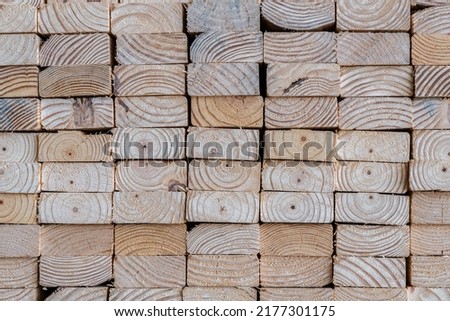 Photograph of the end profile of a stack of 2 x 4's in a lumber yard featuring the wood grain