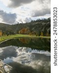 Photograph of fall colors and cloudy sky reflecting in the pond at Kayler