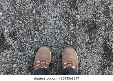 A photograph of the feet of a person wearing hiking boots, on a black sand beach in Iceland. - Powered by Shutterstock