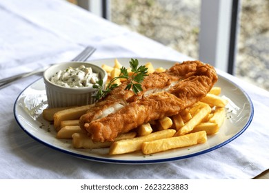 Una fotografía de un plato recién preparado de pescado crujiente y patatas fritas