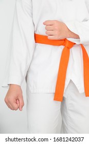 Photograph Of Girl In White Kimono And Orange Belt In Tae Kwon Do Guard Position. Photo In Vertical. Martial Arts Concept.