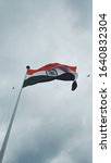 A photograph of the Indian flag fluttering in the air on an overcast day in Central park, inner circle, Connaught place, Delhi, India; tricolour flag of India 