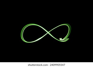 A photograph of an infinity loop symbol in vibrant green light in a long exposure photo against a black background. Light painting photography