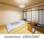 Photograph of a Japanese-style bedroom representing the core of Japanese design, including tatami mats that cover the floor, shoji doors and fusuma walls made of rice paper, and a futon mattress.