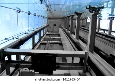 Photograph Looking Up a Glass Elevator Shaft at the Exterior of a Historic Building