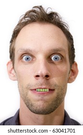 A Photograph Of A Male Holding The Component From A Spirit Level In His Mouth With His Eyes Wide Open. A Close Up Studio Isolation Against White Copy Space.