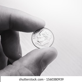 Photograph Of A Man Holding An American Dollar Dime.
