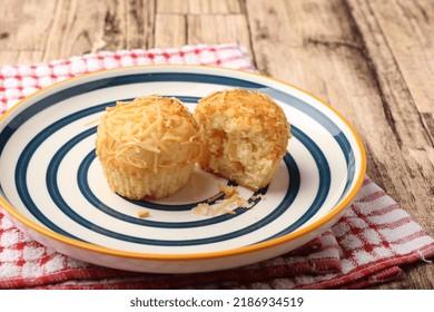 A Photograph Of A Muffin Cake Topped With Fresh Homemade Cheese Crumbs On A Blue Circle Plate. One Of The Muffins Was Cut On A Wooden Canvas And A Red And White Checkered Cloth.