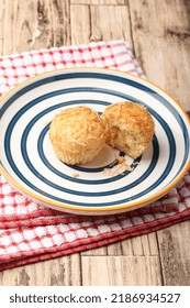 A Photograph Of A Muffin Cake Topped With Fresh Homemade Cheese Crumbs On A Blue Circle Plate. One Of The Muffins Was Cut On A Wooden Canvas And A Red And White Checkered Cloth.