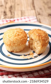 A Photograph Of A Muffin Cake Topped With Fresh Homemade Cheese Crumbs On A Blue Circle Plate. One Of The Muffins Was Cut On A Wooden Canvas And A Red And White Checkered Cloth.